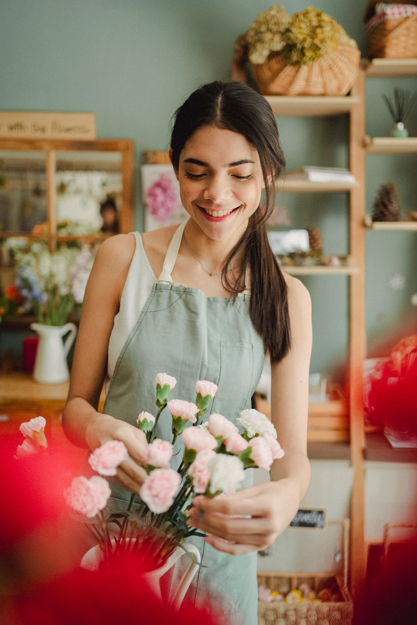 Une fleuriste souriante dans son atelier — photographie d’illustration